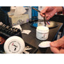 Photo of shave cream open on barber station while holding a blade